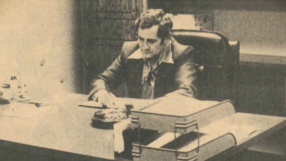 sepia tone photo of a man sitting at a desk